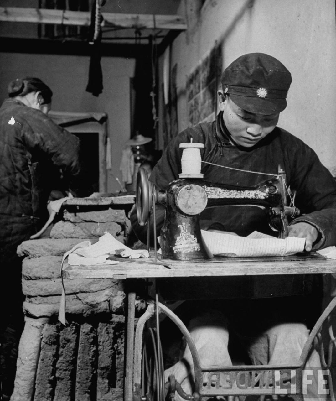 1947年，陕西临潼。缝纫铺的裁缝用上了缝纫机，帽子上是中华民国国徽。​​​