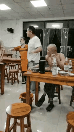 一个光头大哥在馆子里吃面的时候，不知道怎么原因得罪了旁边的一个年轻人，年轻人在那