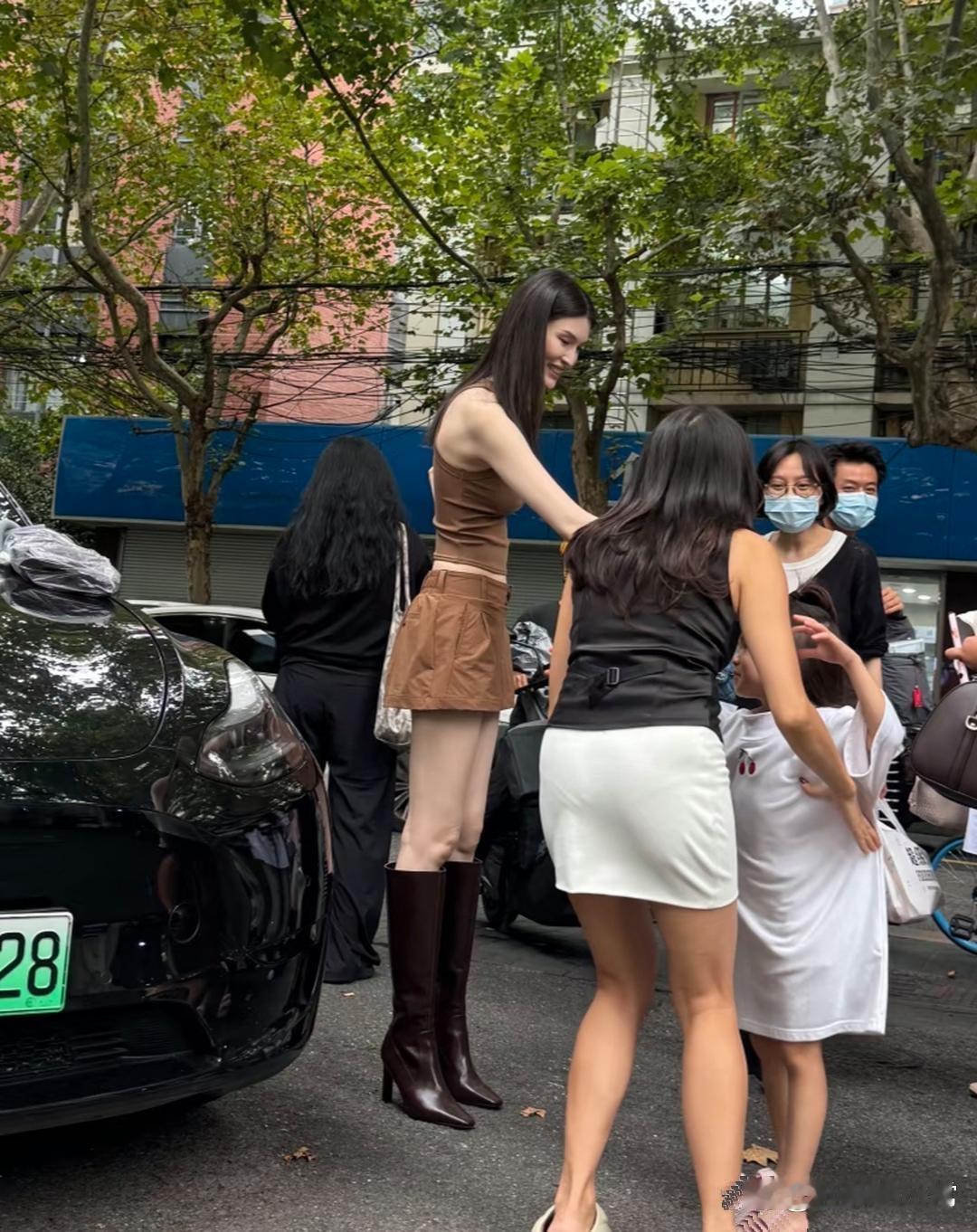 37岁的何穗，在上海街头被人撞见。她穿小短裙配长筒靴，个子高又瘦，看着有一米八。皮肤白得显眼，跟路人