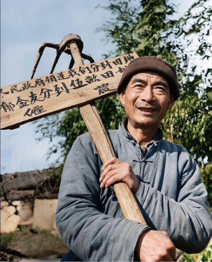 新中国成立初期，雇农郁金友分到土地后喜不自胜的珍贵瞬间。郁金友头戴老式棉帽，身