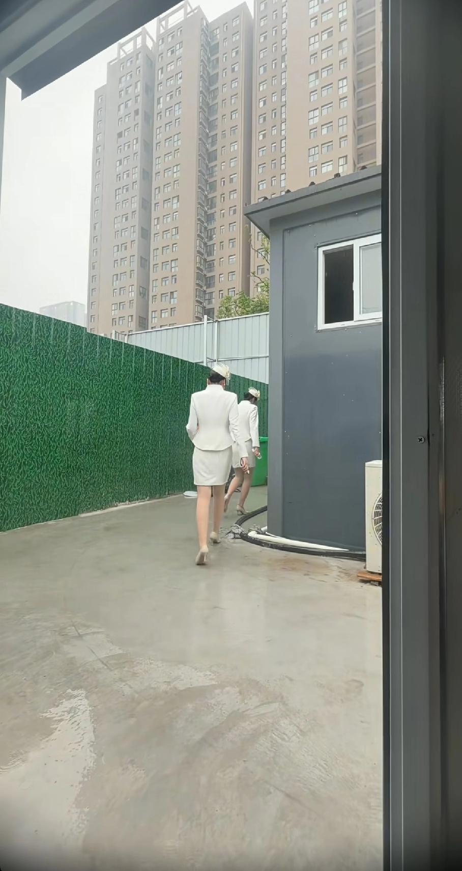 两个穿制服的人走过建筑工地。
