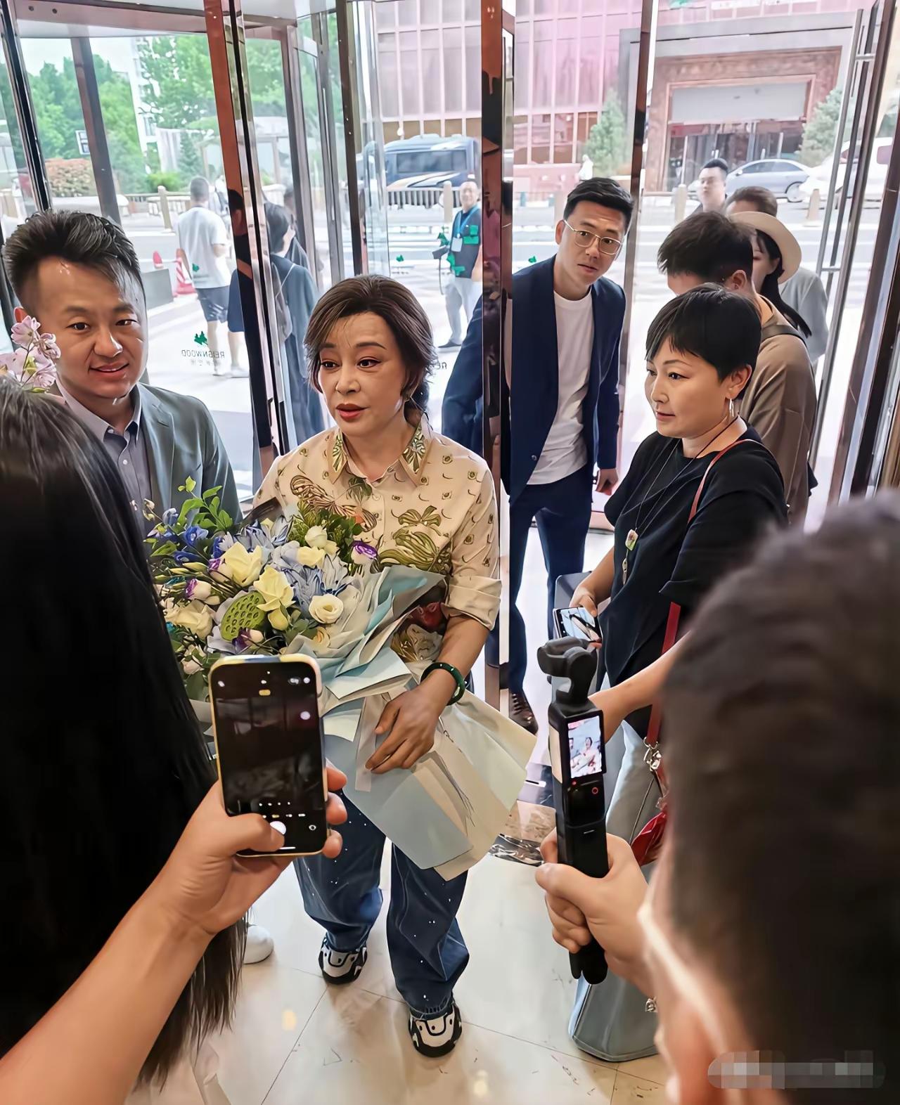 刘晓庆总算正常了一回，她手捧鲜花在北京现身。这次她没头戴鲜花，没穿得花里胡哨，