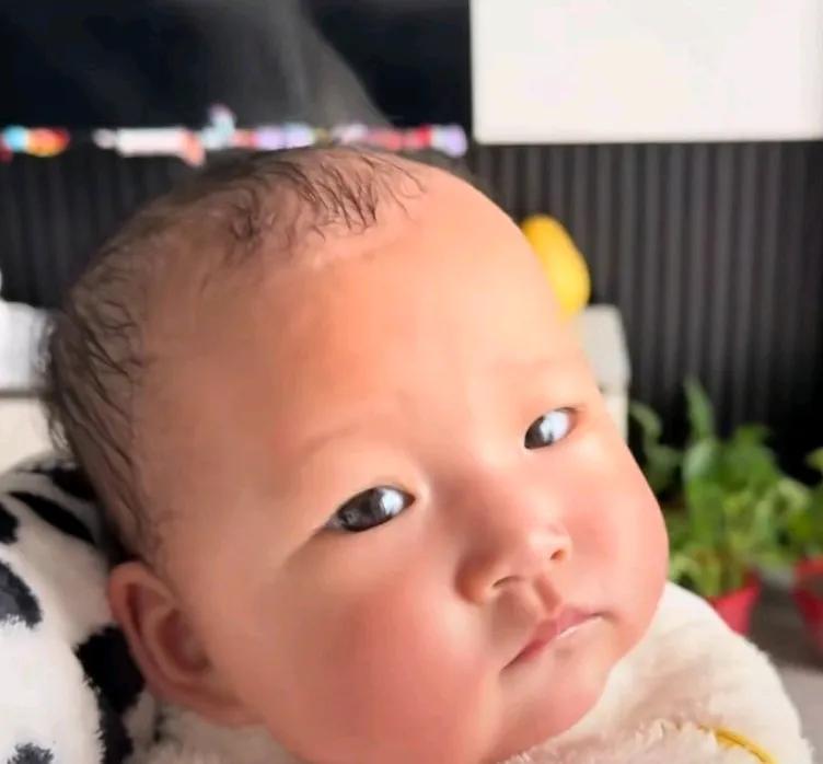 天气冷，妈妈给孩子穿的多，正给孩子喂奶粉，发现孩子头上冒烟了。网友说，吃奶粉有