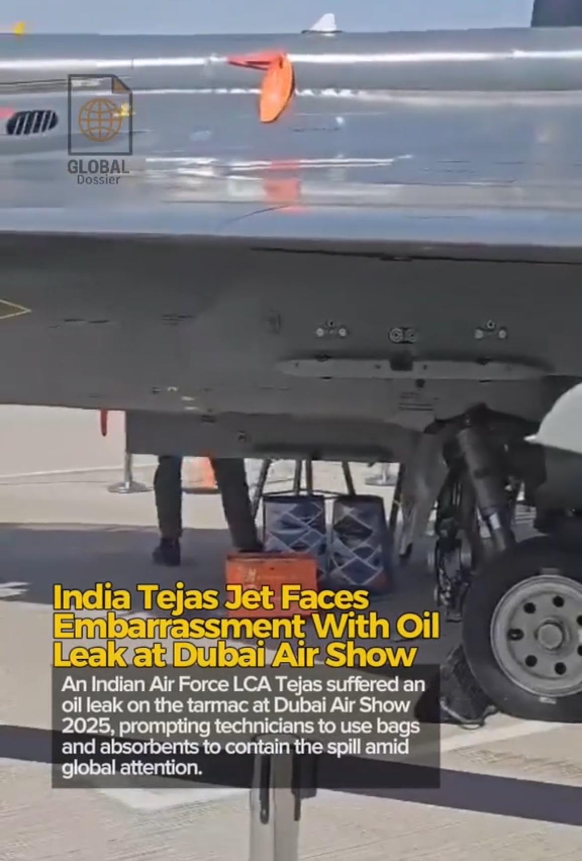 印度一架光辉战机在迪拜航展上漏油，地勤工作人员用购物袋接住渗漏的液体，印度批评报