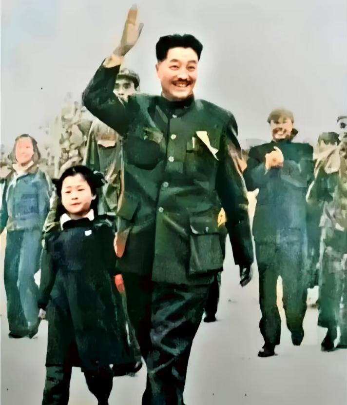 建国初期，贺龙元帅牵着宝贝女儿，走过长安街头，边走边向周围鼓掌的人群，挥手致意。