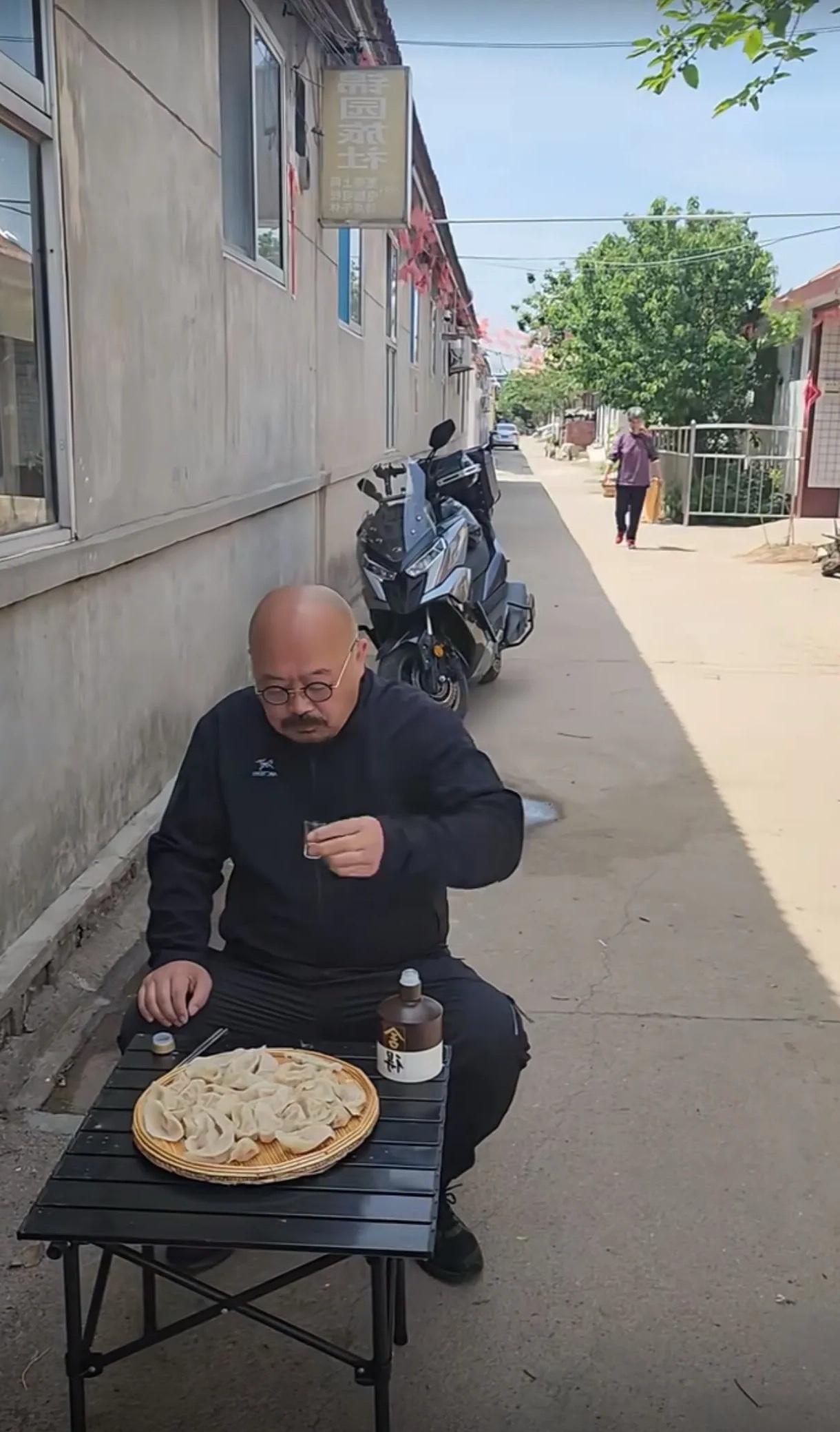 这位朋友是不是全网最像刀郎的一位？独自一人坐在路边喝着酒吃着蒸饺，真是悠哉悠哉！