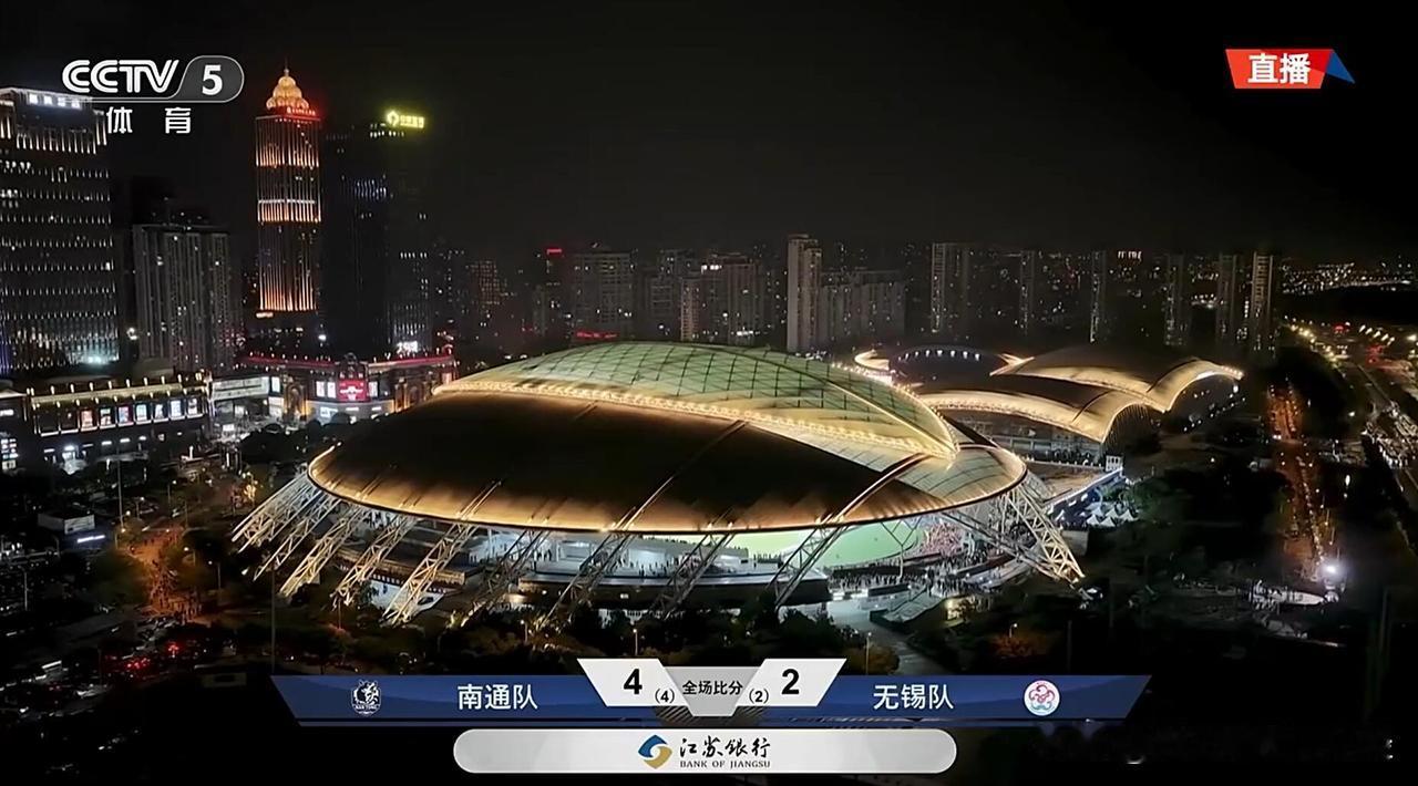 央视直播最后的画面，给出了南通体育会展中心的夜景图，外面下雨，顶棚关闭，背景是南