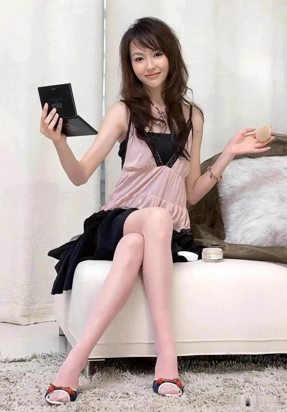 早年唐嫣写真自带甜美的少女气息，蓬松卷发灵动温柔。粉黑拼接吊带裙搭配丝袜，笑容清甜治愈。眉眼精致灵动