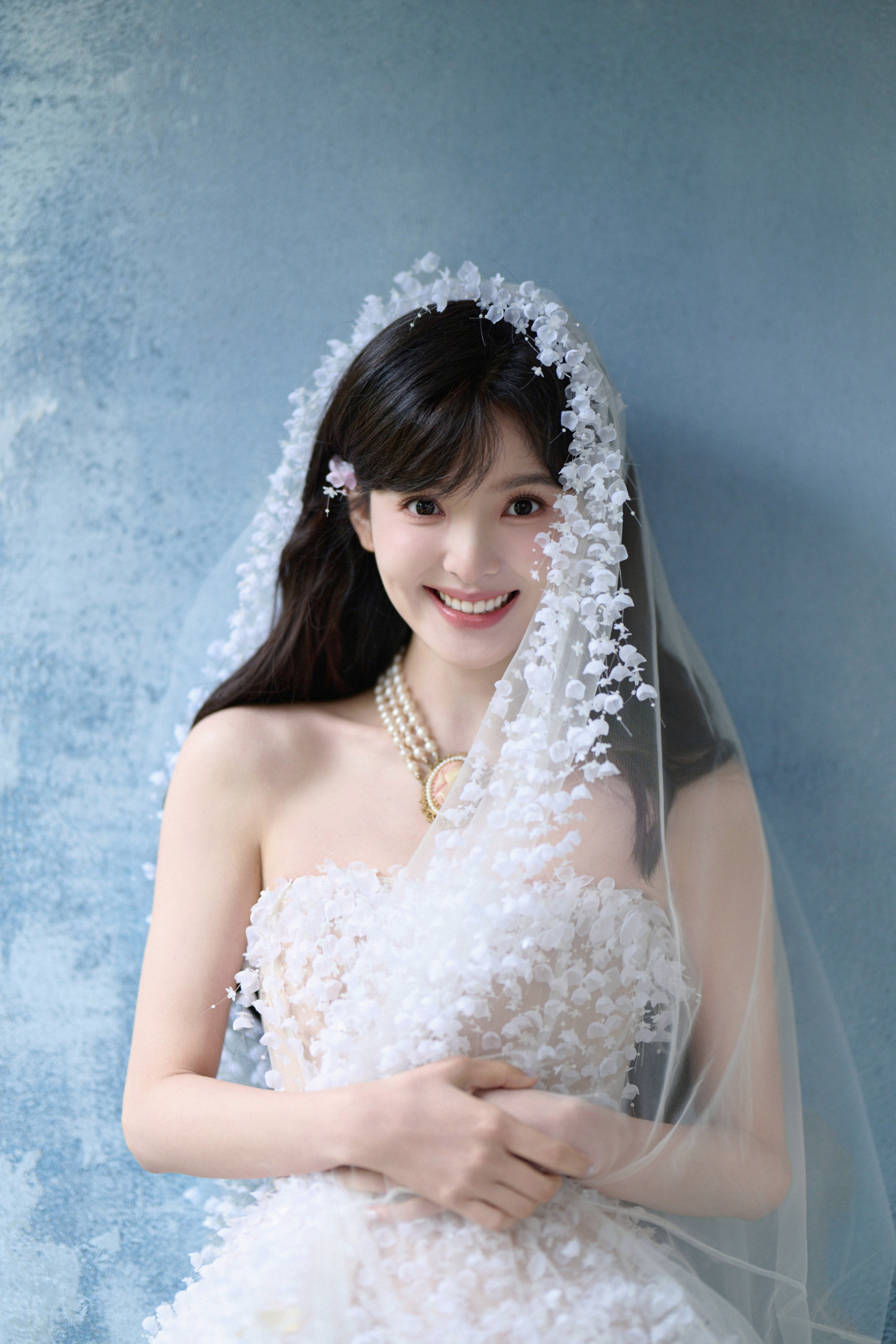 章若楠当白纱缀满细碎的花，像把春日揉进裙摆里。发梢的浅粉与颈间的珍珠相衬，连空