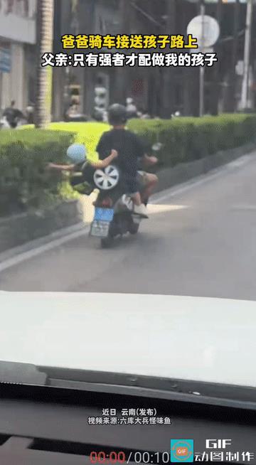 “爸爸带孩子活着就行!”云南，爸爸骑电动车送孩子上学路上，孩子坐在后座眼看就要掉