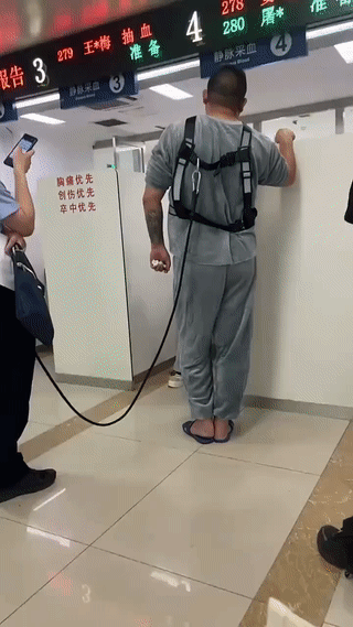 这是网友在医院里拍到的一幕。一名警察带着一个生病的犯人来医院里做抽血化验检查。