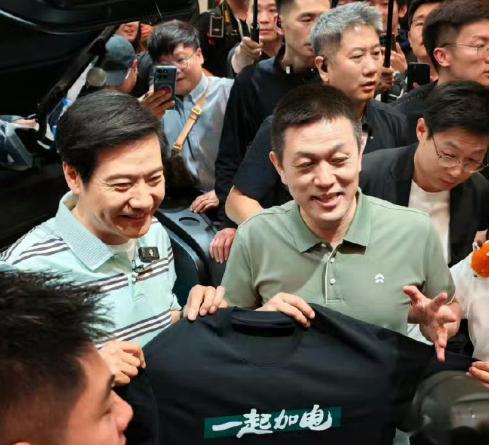 雷军在2026北京车展现场给蔚小理都送了专门准备的衣服，蔚来的“一起加电”跟小