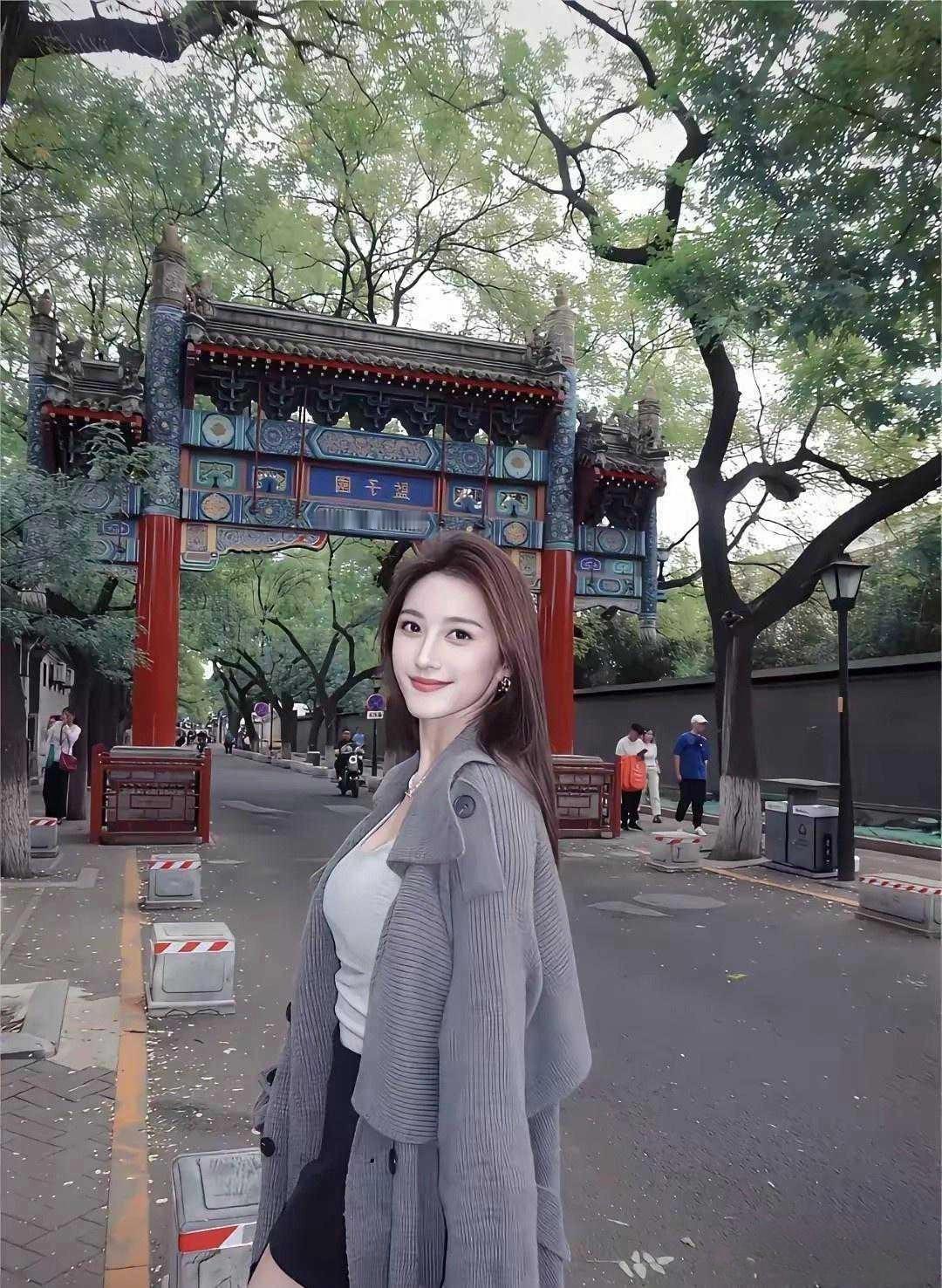 她站在红墙前像一棵银杏在秋阳里舒展金黄的叶片是季节遗落的书签脉络里藏着夏日