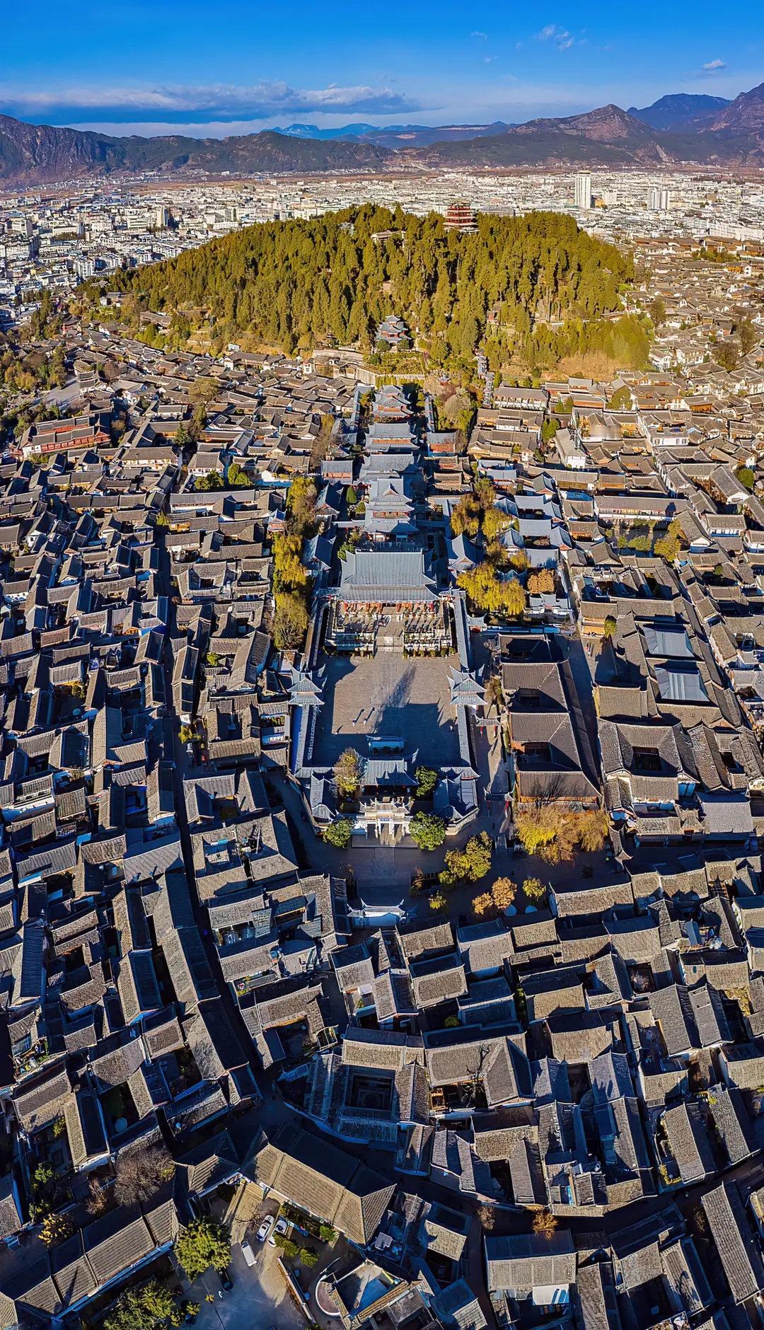 丽江古城青石板路蜿蜒，航拍中古建错落如诗。它始建于宋末元初，是四大古城中保存最完