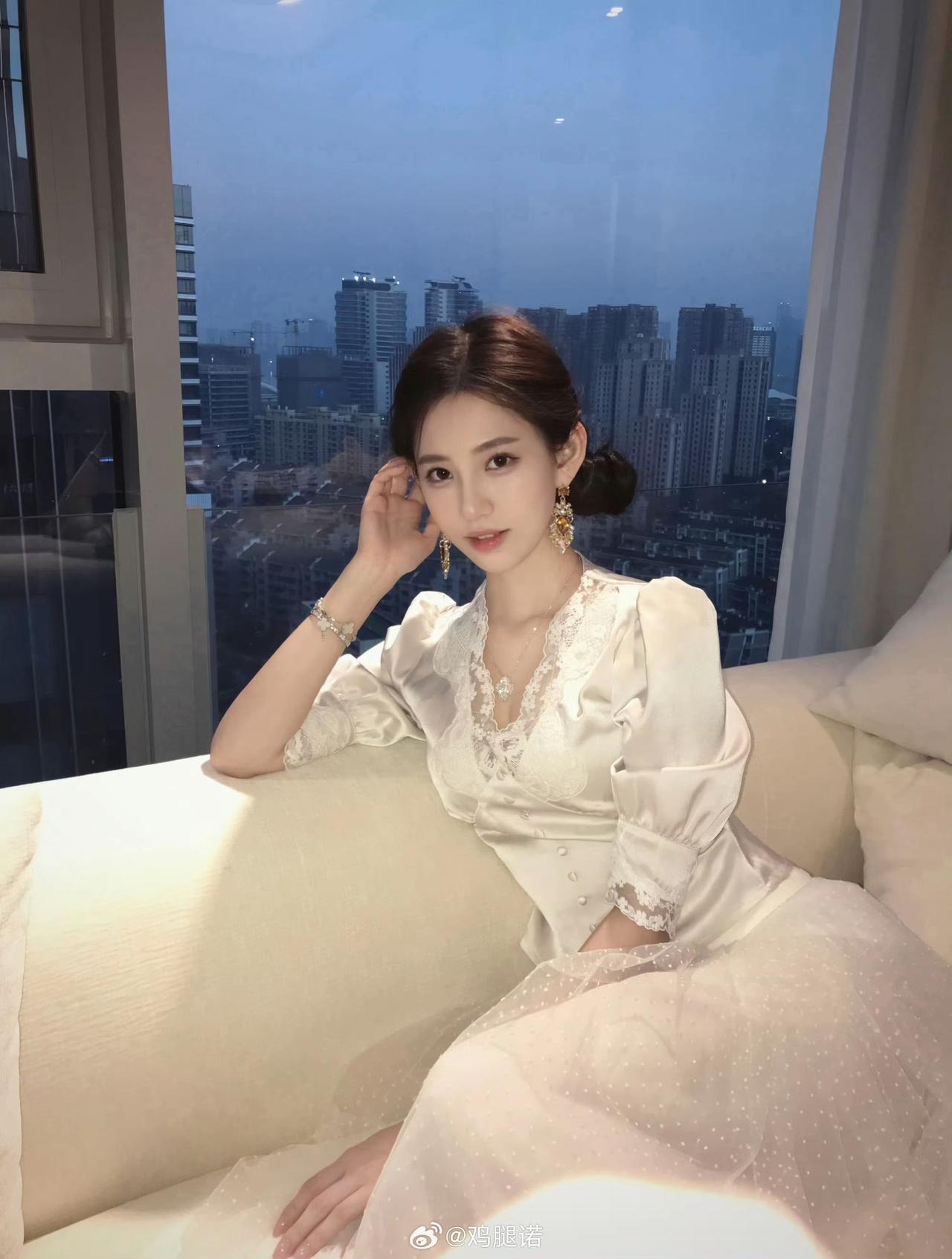 她坐在窗边，看着城市的夜景。