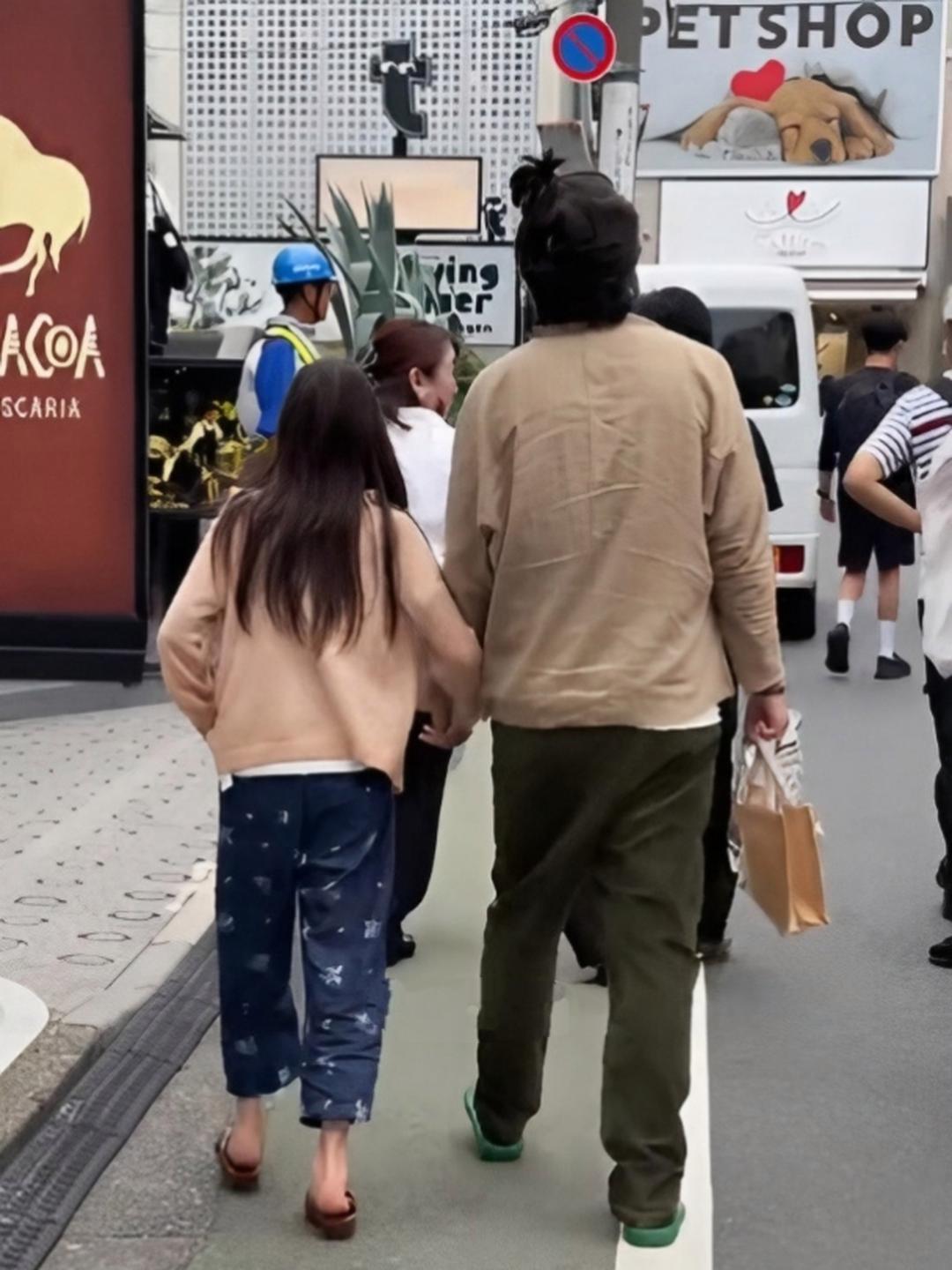 陈冠希趿拉着一双绿色拖鞋，带着女儿现身日本东京街头，他上衣和裤子都是褶皱，而且颜