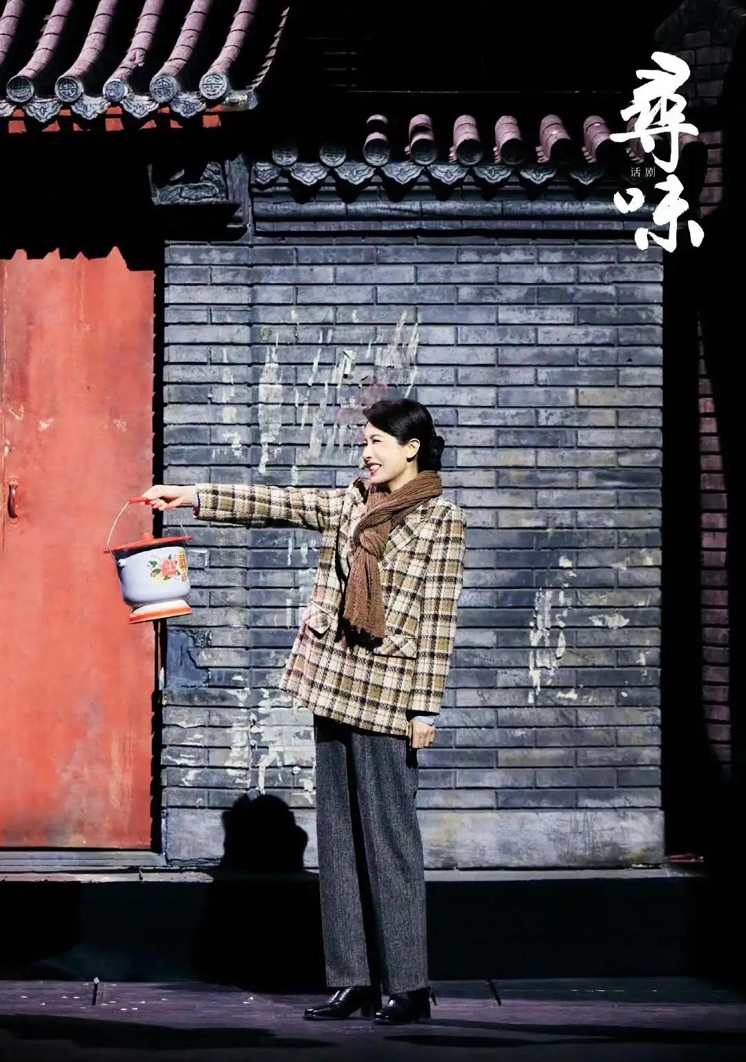 曾黎格纹西装搭配阔腿裤，黑色小皮鞋穿起来，围巾围起来，右手拿着一个有年代感的物件