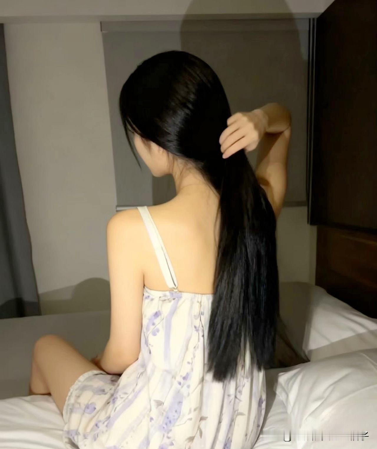 夜晚的柔光下，长发女孩轻轻抚摸着她的秀发，散发着宁静与美丽。