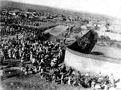 战壕里没活人了。12个俘虏弯腰捡枪，指导员问："想好了？"第一个人说："俺爹也穿