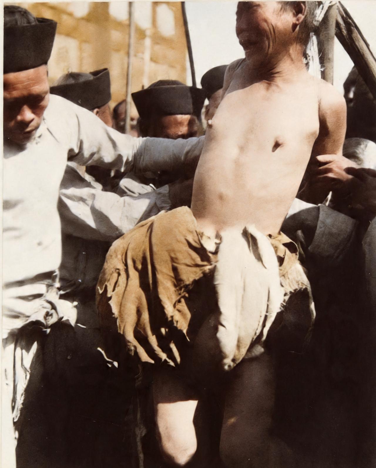 这是晚清一名男子被吊起来实行凌迟。这名男子知道自己要被实行凌迟时惊吓得五官移了位