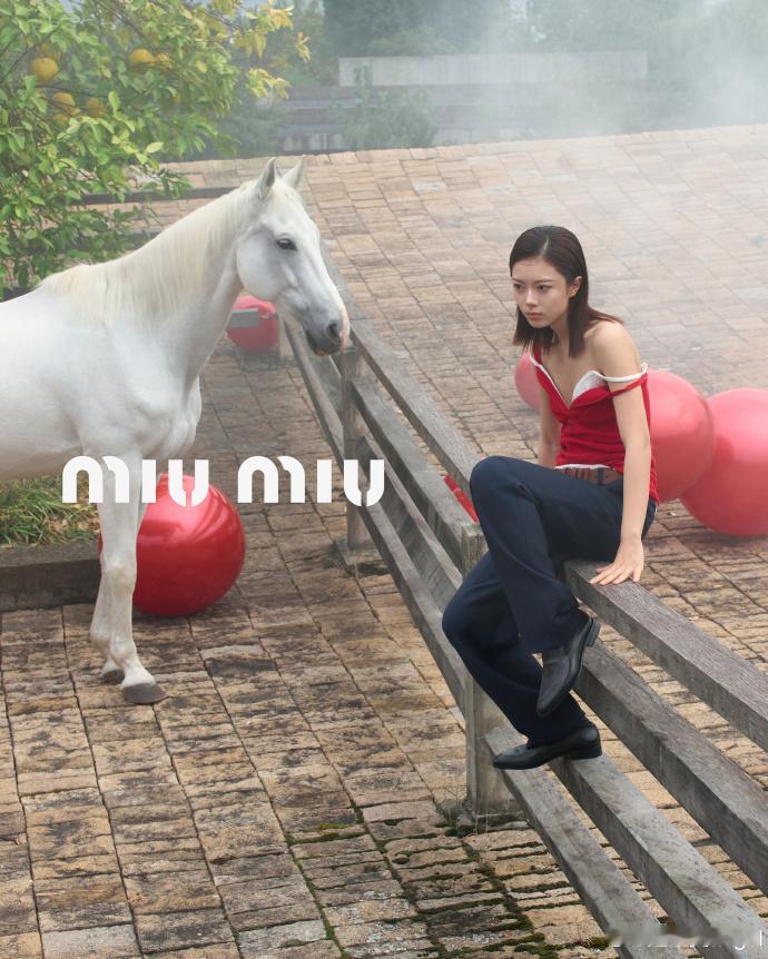 最新曝光的MiuMiu大片里，赵今麦身着马年红裙出镜，裙身同色徽标彰显品牌辨