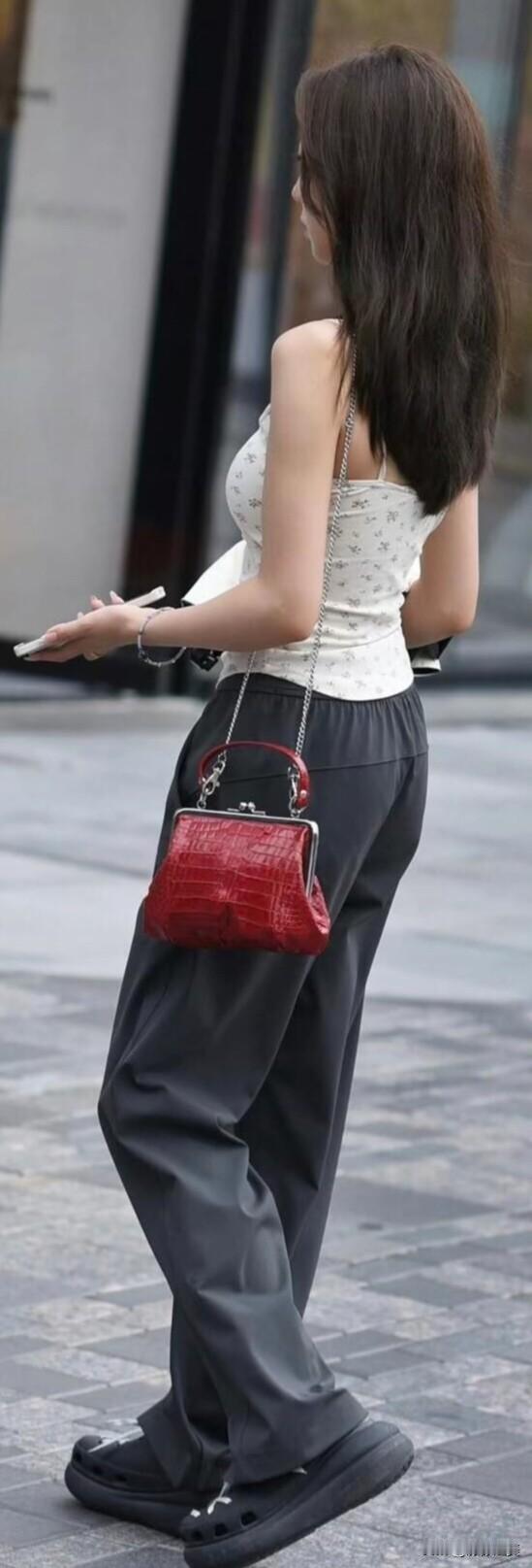 街头这位女生穿搭很有巧思，碎花吊带配灰色阔腿裤，红色小包点睛，再搭双厚底鞋，休闲