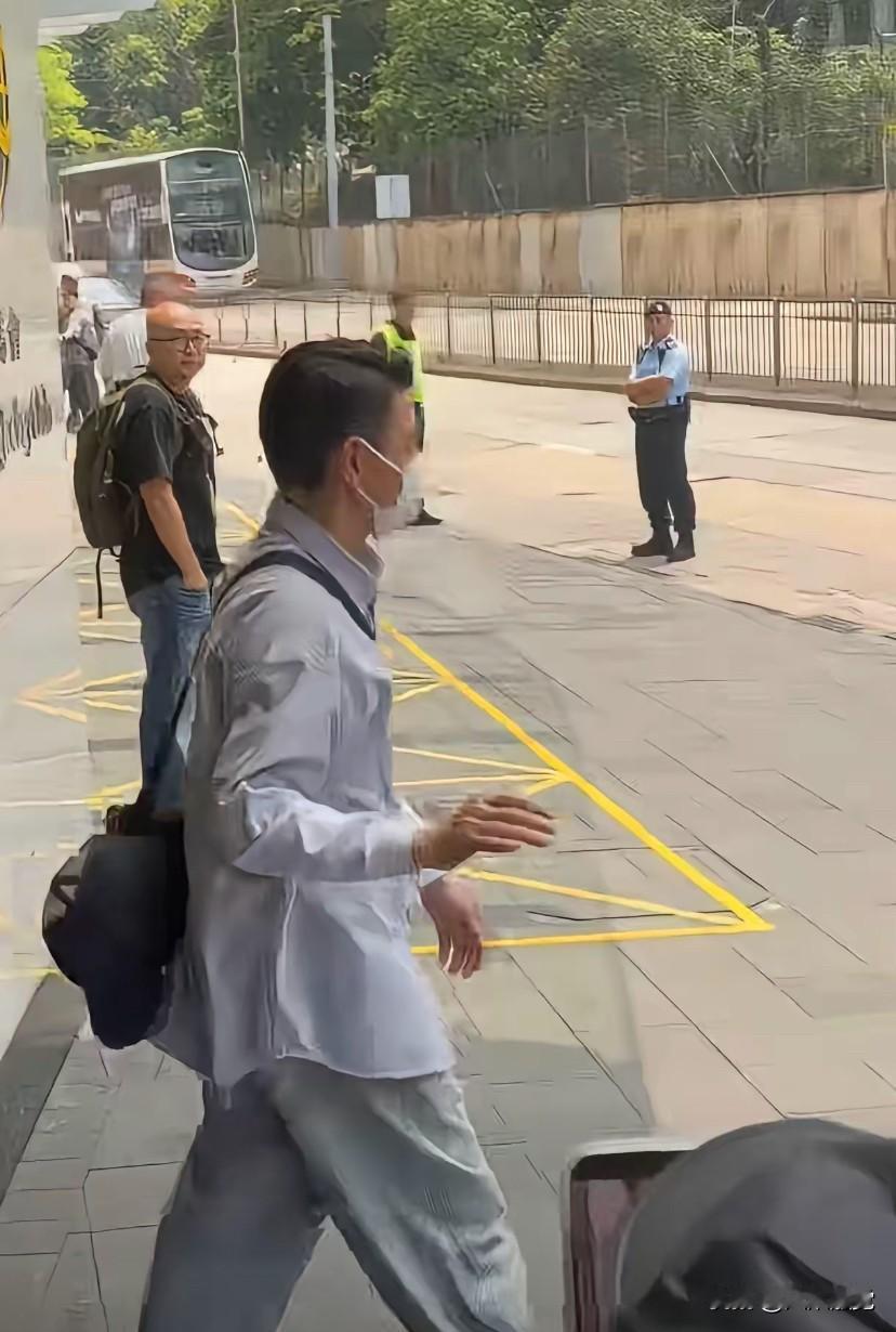 香港大明星刘德华穿着休闲衬衫，过肩背着个小包，迈着轻快的步伐走出来，一个跨步就踏