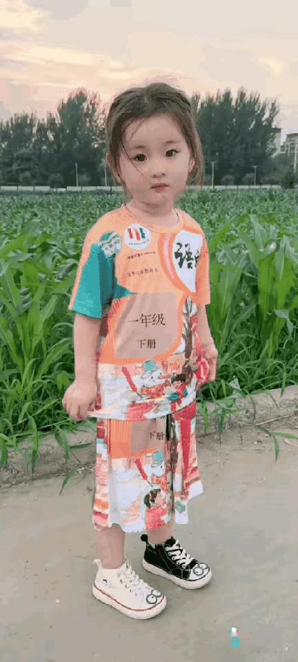 小朋友非常的天真，非常的可爱，可是穿的鞋不是一样的颜色，一只鞋是黑色的，一只鞋是