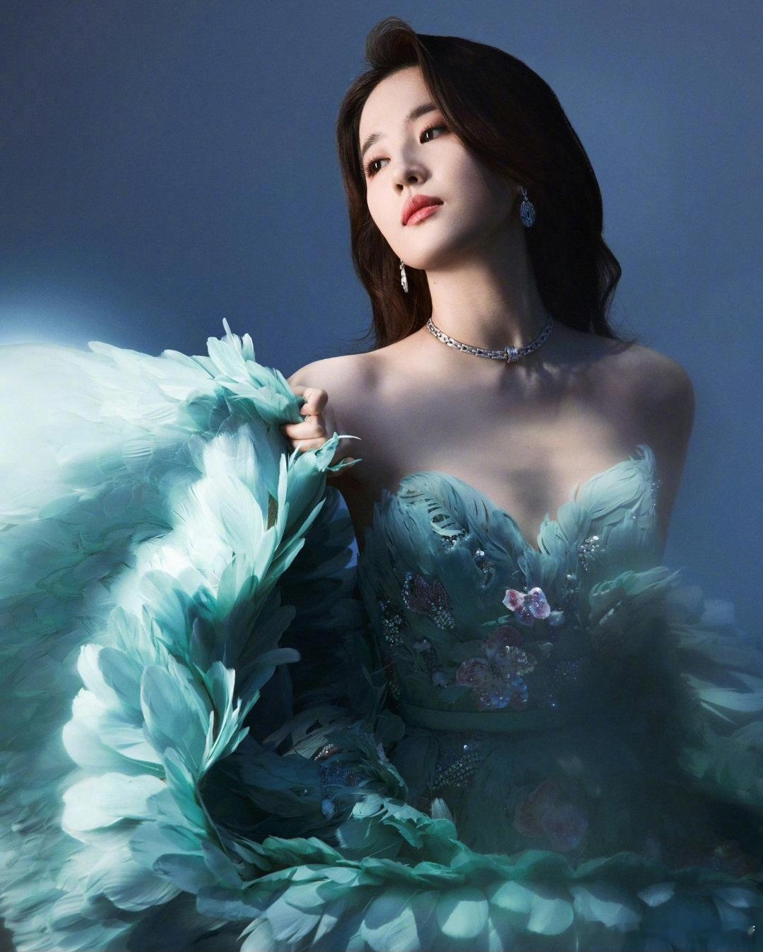 在这组照片中，刘亦菲身着一袭极具梦幻感的薄荷绿抹胸羽毛裙，裙身由层层叠叠的轻盈羽