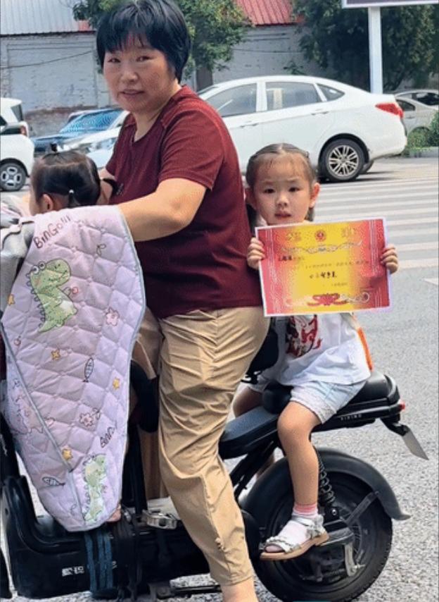 这下全国人民都知道了！路上偶遇一小女孩，手里一直举着自己的奖状，等红绿时看到有