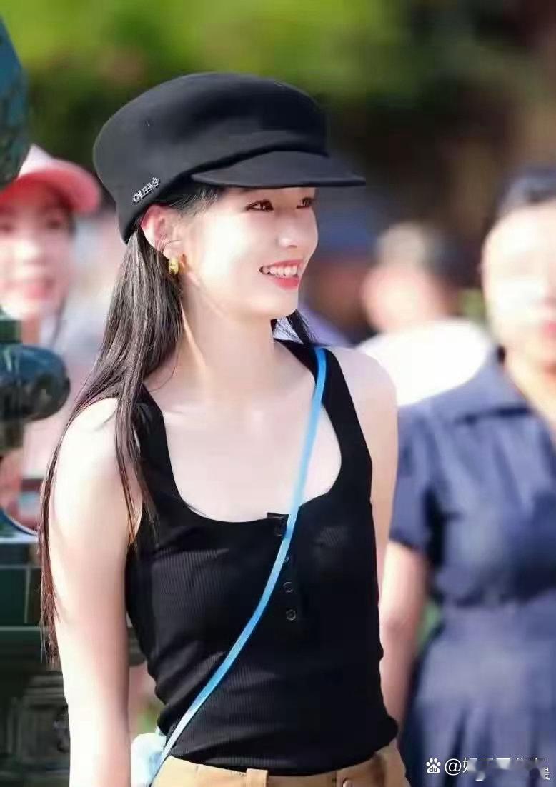 周也头戴黑色帽子，简约黑背心搭配驼色短裤，穿搭清爽利落，气场满满，氛围感十足，妥