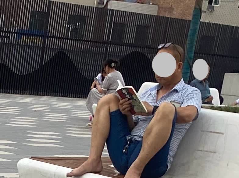 哈哈，贾平凹小说《暂坐》外边散步，见一中年男子坐在休闲坐上在非常认真读贾