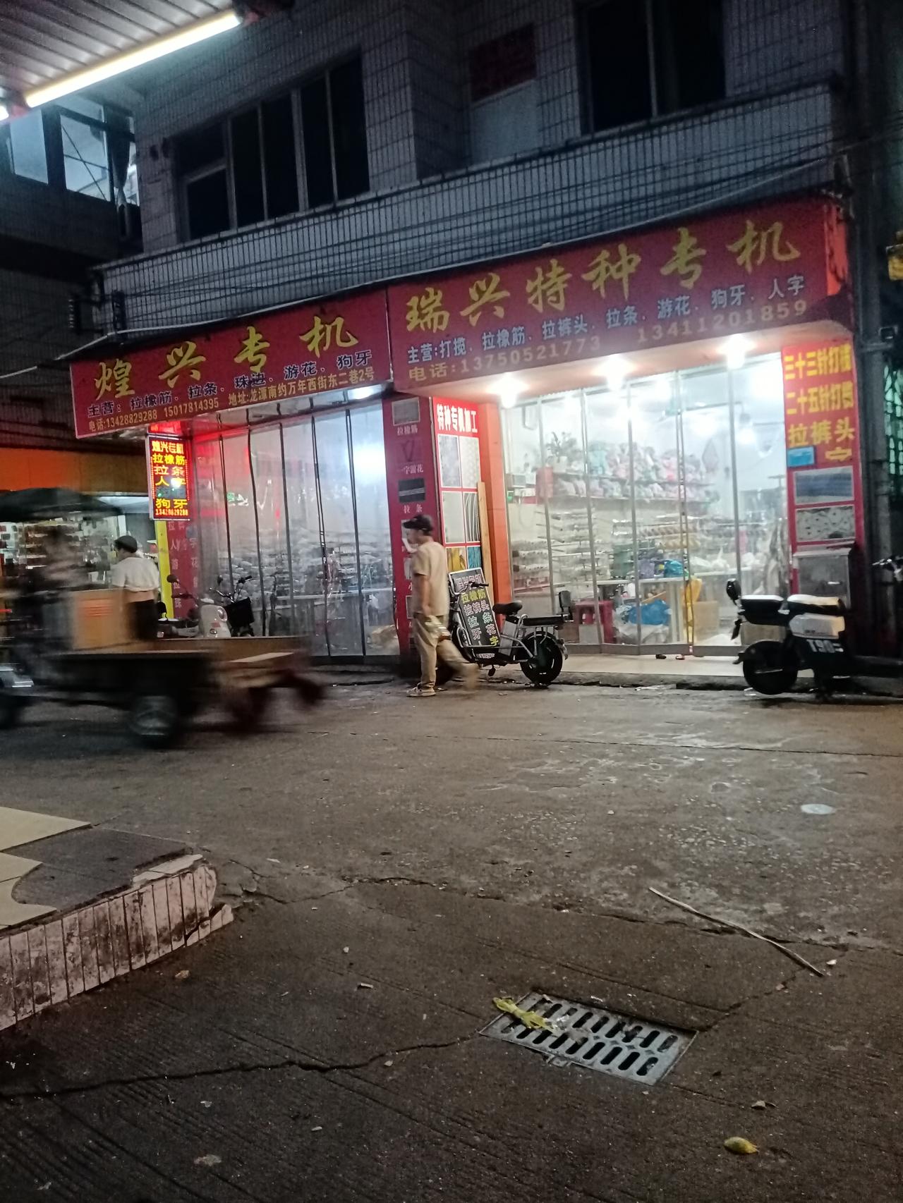 广州海珠区龙潭村万年东街主干道，两旁的店铺好多都是专机店，为上衣裤子做加工的后工