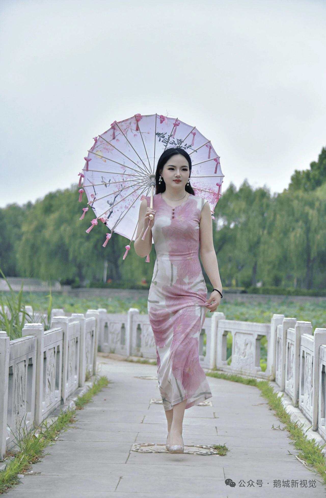 粉黛佳人漫步古桥，撑伞漫步在绿意盎然的江南水乡。