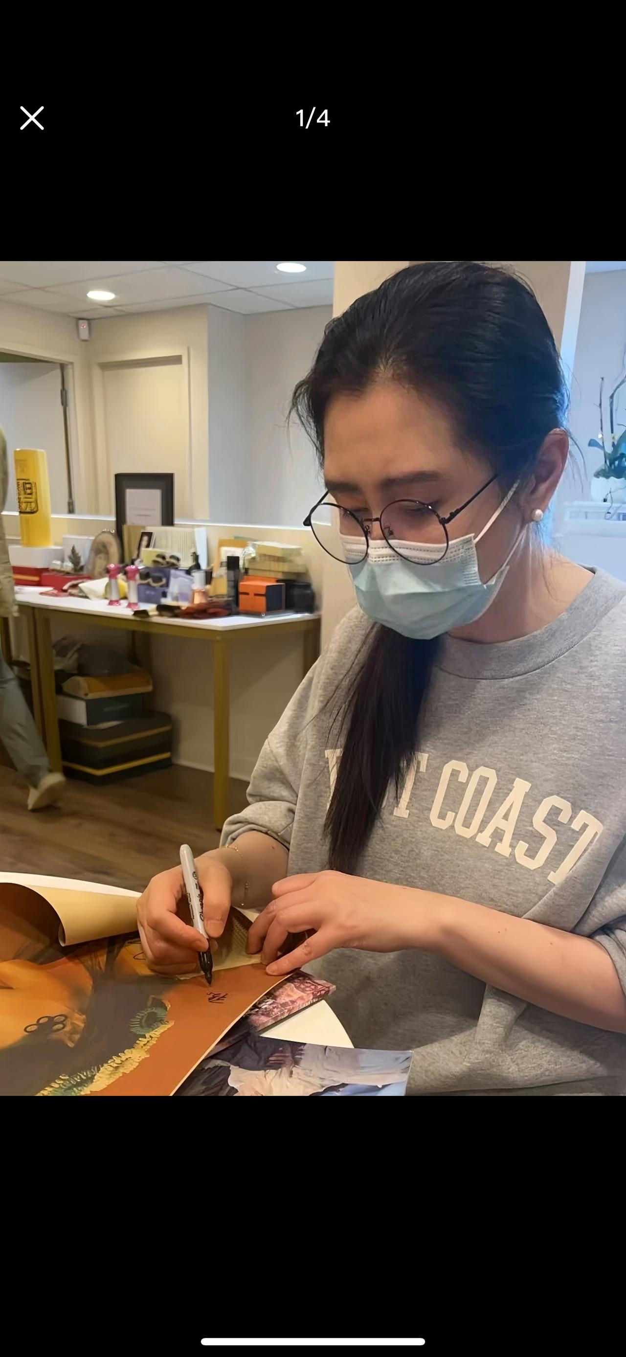 给粉丝做完艾灸，王祖贤还不忘给粉丝签名留念。这张照片中，王祖贤身穿休闲卫衣，