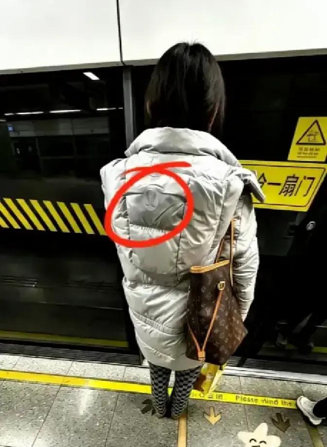上海地铁里一个姑娘背着LV挤早高峰，外套却是几百块的哑光羽绒服，照片一出全网炸锅