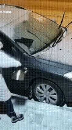 这大姐的操作真让人哭笑不得！下雪上冻想除挡风玻璃的冰，居然直接拎了壶滚烫开水浇上