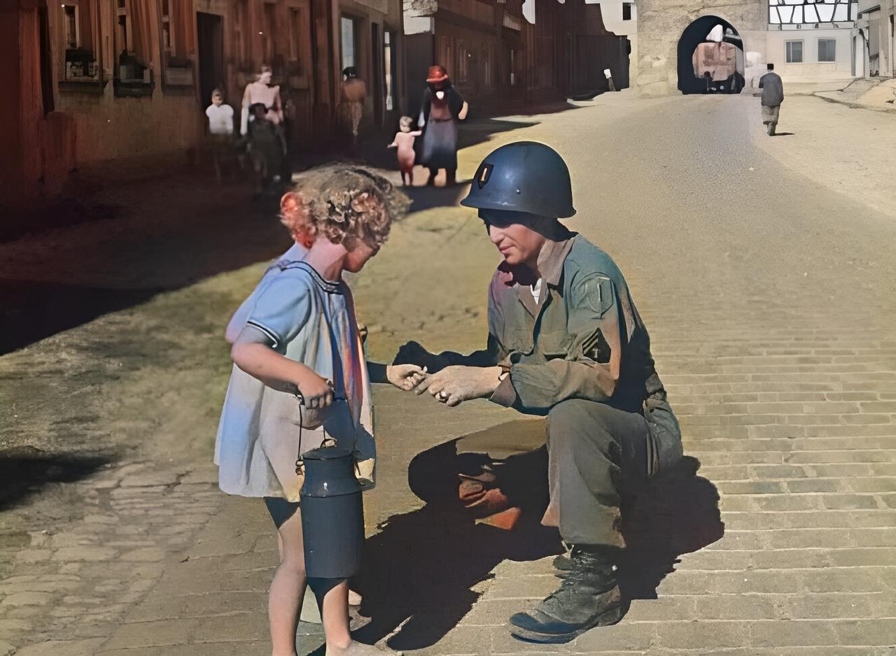 这是1945年美军攻占德国的谢菲尔德后，一名美军士兵在路上遇到两名饥肠辘辘、赤着