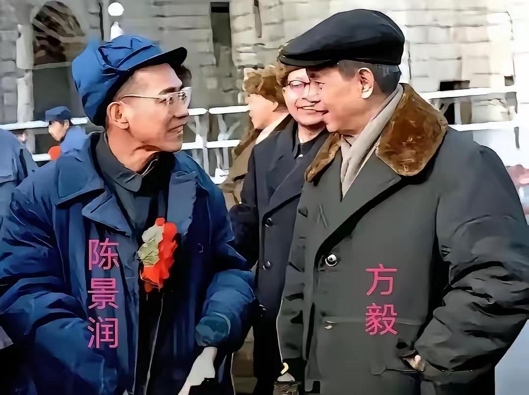 这就是我们的大数学家陈景润，身着朴素蓝色棉大衣、布帽，戴着深度眼镜。他正在和时任
