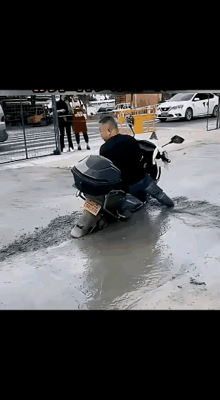 这个大哥还这么磨蹭干啥？赶紧给钱请几个有力气的人把摩托车抬出来，然
