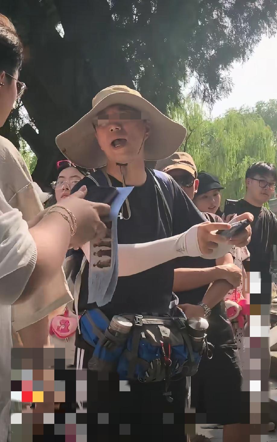 6月14日，山西太原晋祠景区网红打卡点，上百人正在有序排队等候拍照。一名戴帽子的