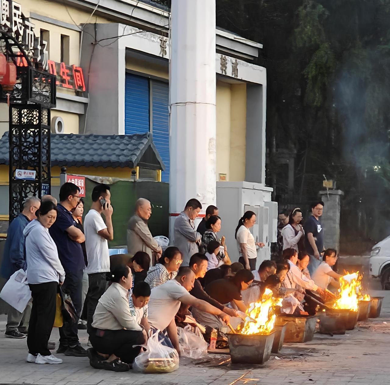 中元节一波又一波虔诚的人们，在一团团“纸钱”燃烧的炙热火焰