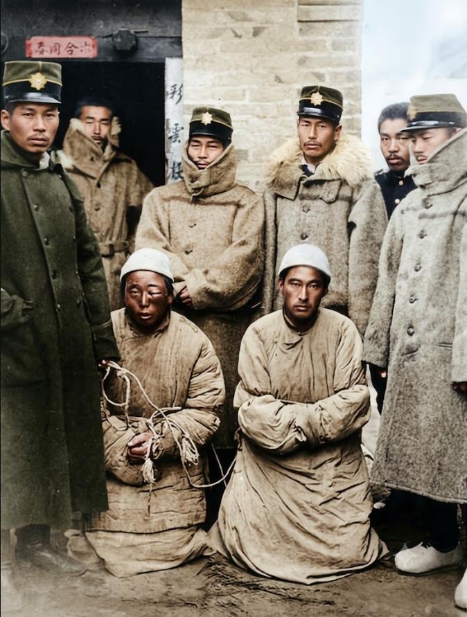 1894年，甲午中日战争期间，一处中式砖造民居门前，两名被俘的清军便衣侦察兵。前