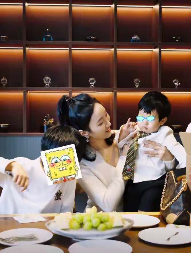 黄晓明一家4口参加生日宴，小海绵被奶奶搂在怀中，长腿溢出屏幕