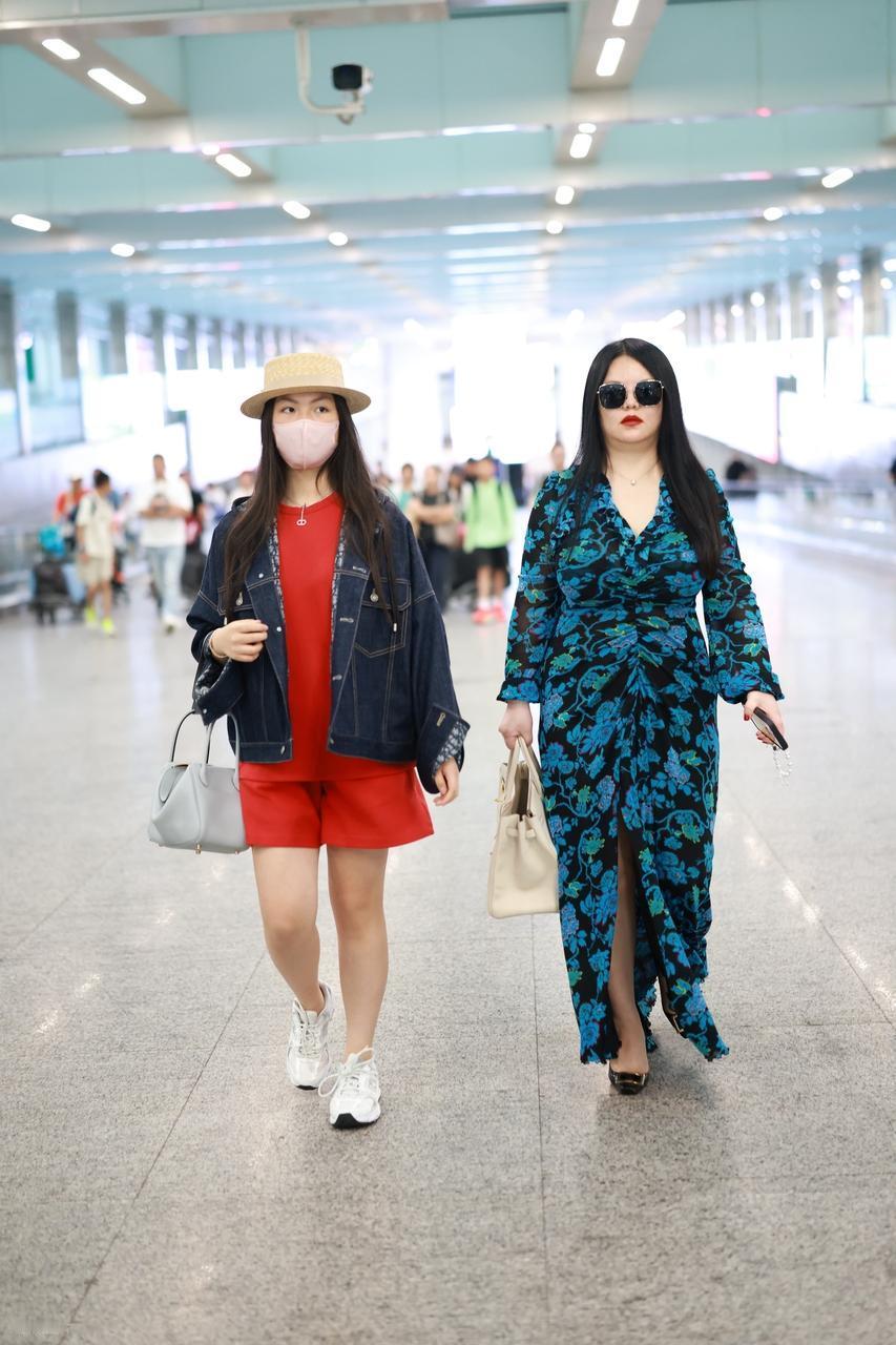 今天李湘和女儿王诗龄一起现身北京机场，两位走在一起很有姐妹范儿。李湘穿了一件