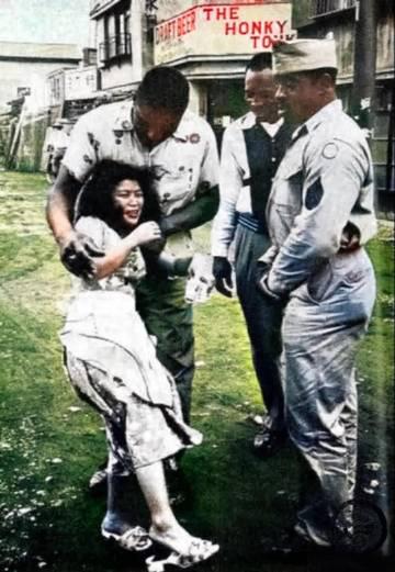 照片上是二战结束后，占领日本的3个米国大兵当街将日本一个妇女强行抱走。据日本
