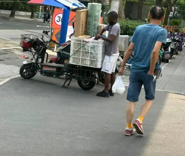 有上海网友拍到一黑人在做快递小哥他有务工许可证吗？要知道，就算一个女的娶了这个黑
