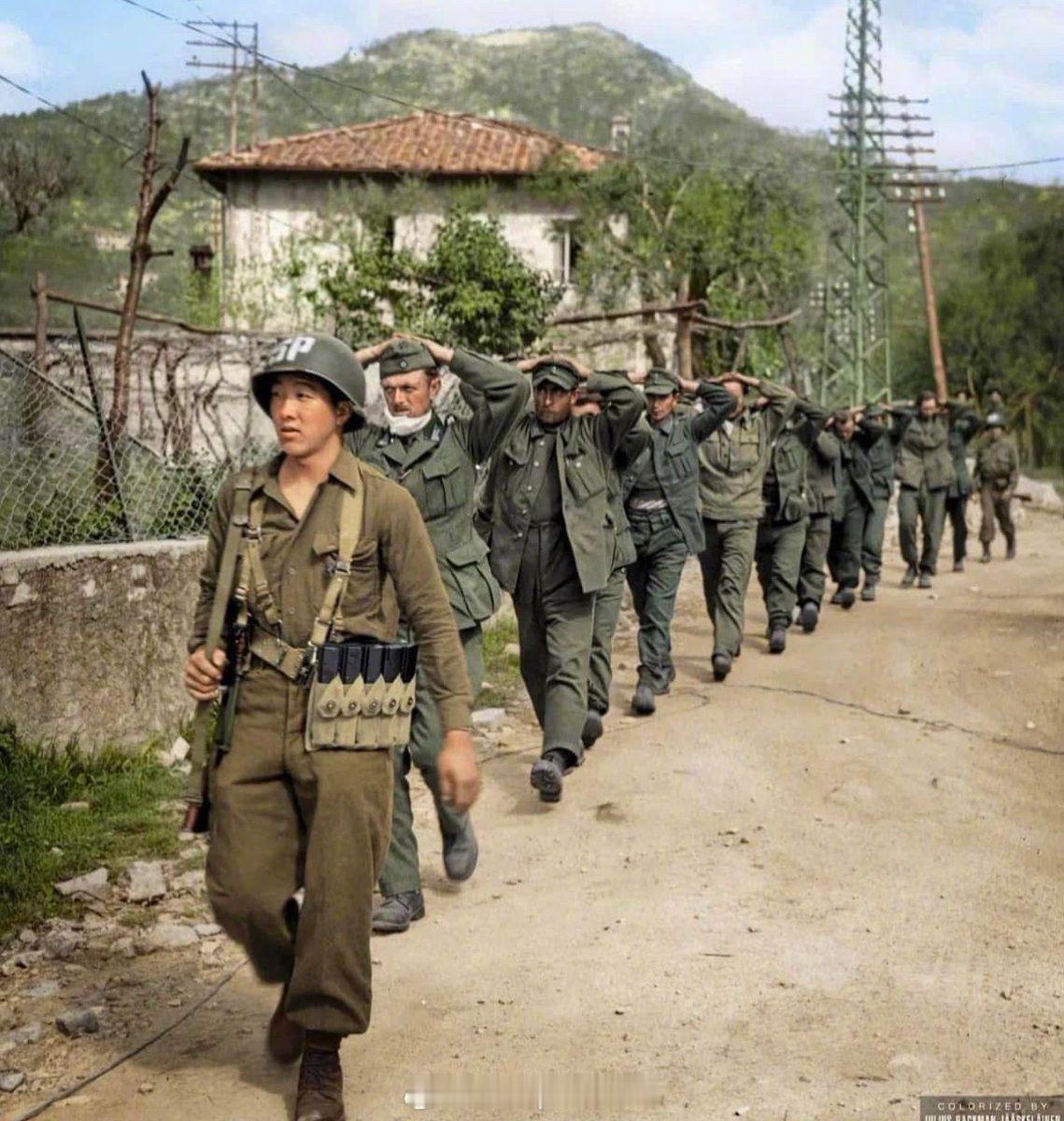 照片中的历史1945年4月，美军日裔士兵山岸三郎带领由第100步兵营俘获的德国