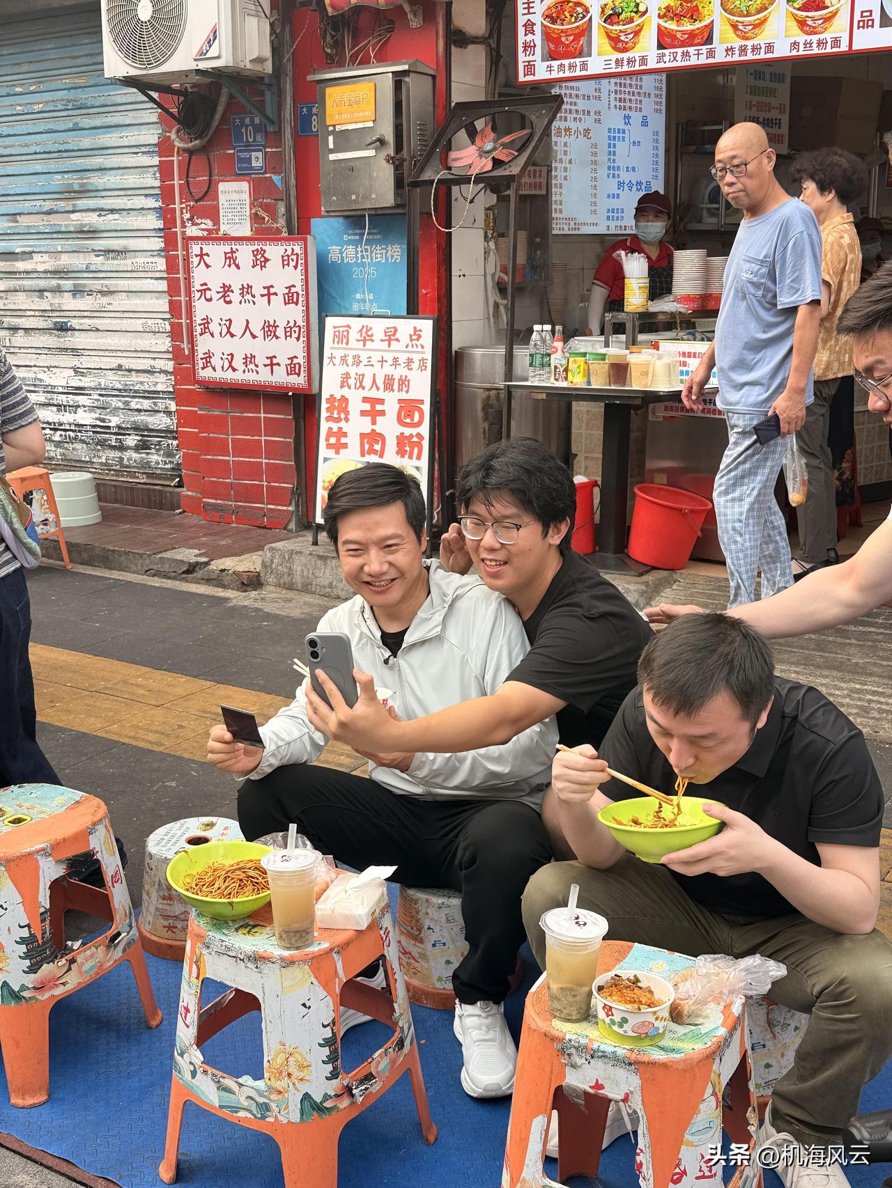 请问这个抢着跟正在吃热干面的雷军合影的小伙的手机型号？