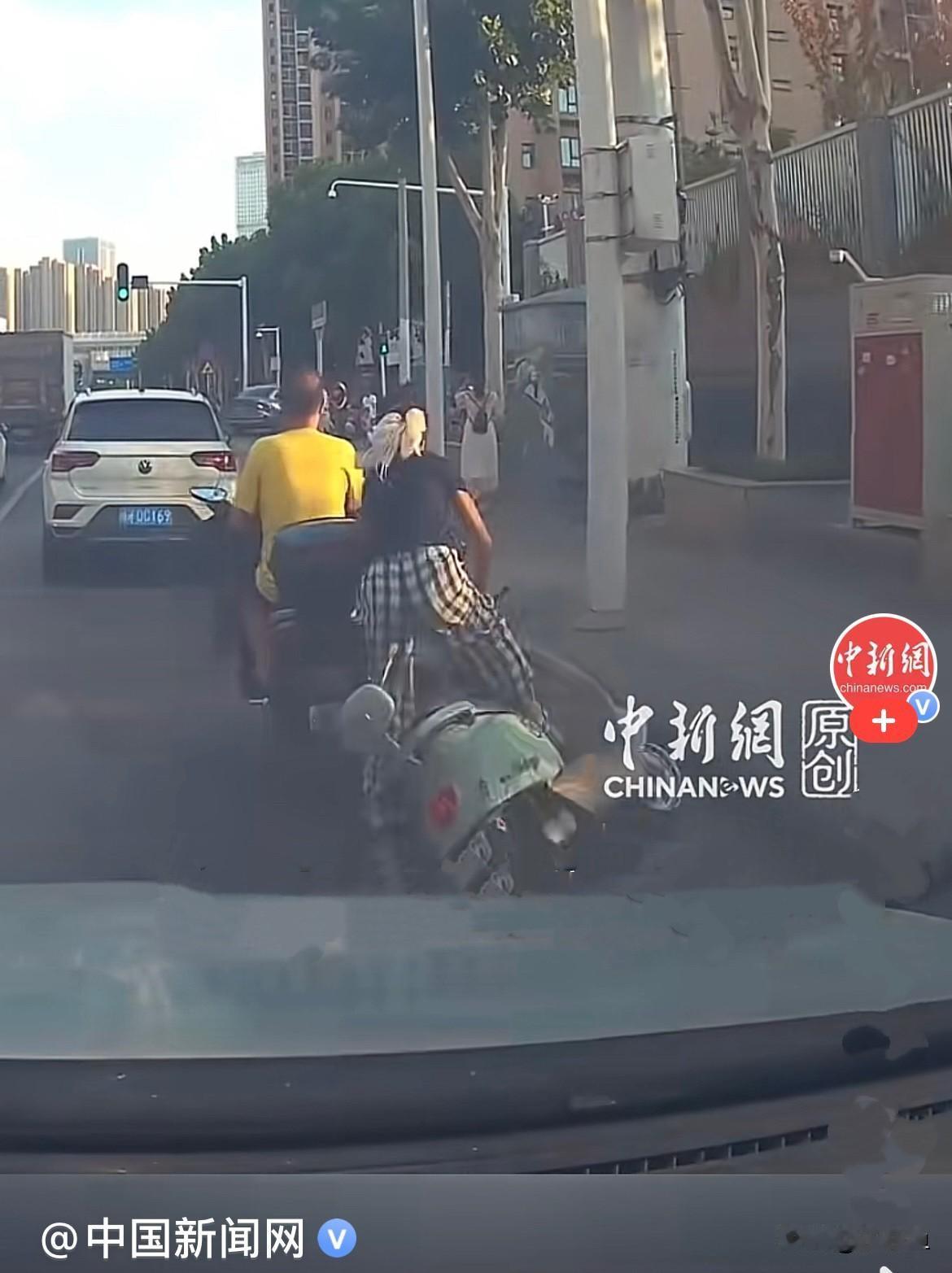 近日，湖北武汉晚高峰，繁华马路上，一名女子规规矩矩骑着电动车，正常跟随车流行驶，